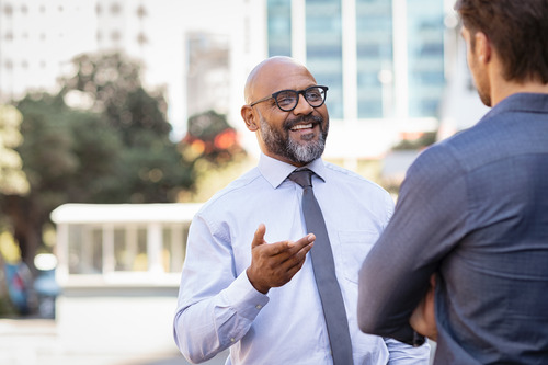 A senior businessman and a gen Z businessman talking about temp work